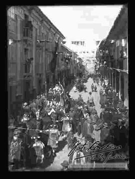 Desfile de colegios por las fiestas patrias del 6 de agosto, en la calle Mercado, donde se puede apreciar una carrosa adornada con niños disfrazados y un hombre vestido como el Rey Baco.