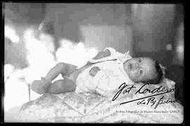 Un bebe recostado sobre un cubrecama