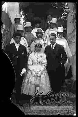 Pareja de novios. chola junto a su pareja y familiares delante de la puerta de una casa particular,  el día de su matrimonio