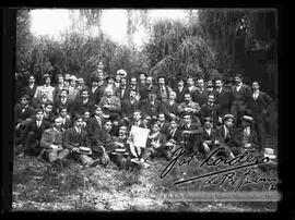 Grupo de médicos y amigos en el patio  y chacra de una casa particular, celebrando un acontecimiento