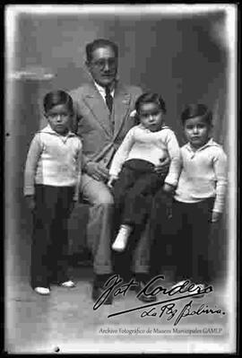 Foto de estudio de un padre junto a sus tres hijos