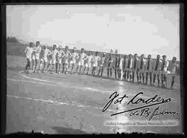 Dos equipos de futbol en una  cancha de tierra