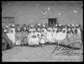 Reunión de un grupo de personas en el patio de una casa particular por la celebración de una fiesta patronal en honor a un santo.