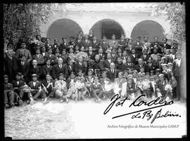 Jóvenes y adultos en el día de su primera comunión junto  un cura en el patio del convento de San Francisco