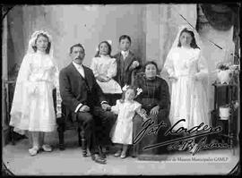 Foto de estudio de dos niñas junto a su familia, el día de su primera comunión