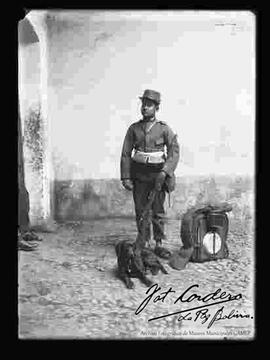 Soldado de la expedición al Acre, parado junto a un perrito, con su equipo de campaña