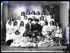 Foto de estudio de un grupo de señoritas estudiantes de colegio junto a profesoras