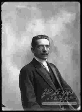 Fotografía de estudio. Imagen de medio cuerpo de un varón con bigote.