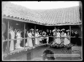 Novios junto a familiares e invitados en el balcón de una casa particular, celebrando su matrimonio