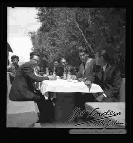 Miguel Alandia Pantoja con Julio Cordero Ordoñez y su grupo de amigos, compartiendo bebidas en una quinta (restaurante).