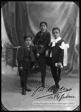 Foto de estudio de tres niños. en el día de su primera comunión