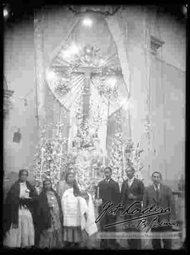 Fiesta patronal. Prestes sosteniendo la imagen de una virgen, delante del altar de una iglesia.