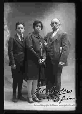 Foto de estudio de dos jóvenes parados junto a su abuelo