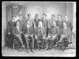 Foto de estudio de un grupo de jóvenes universitarios, junto a su catedrático