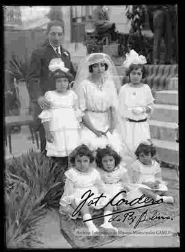 Novios junto a unas niñas, en el patio de una casa particular, en el día de su matrimonio