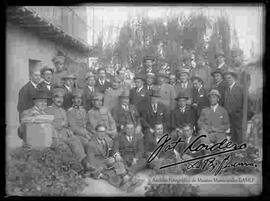 Grupo de varones y militares, reunidos en el patio de una casa particular