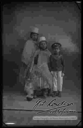 Foto de estudio de una familia, dos cholas y un niño.