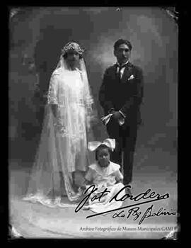 Foto de estudio de una pareja de novios, en el día de su matrimonio junto a una niña