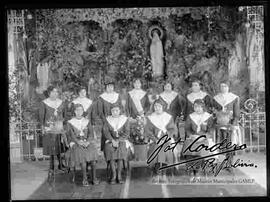 Grupo de señoritas estudiantes del colegio Santa Ana, uniformadas y con el fondo de la imagen de la virgen