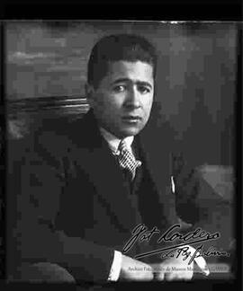 Reproducción de la fotografía de un varón que viste de traje y que se encuentra sentado.