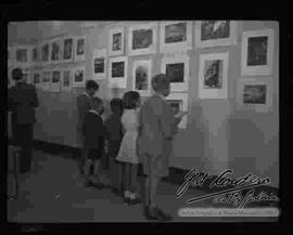 Niños observando la exposición de fotografías "Foto Cordero Jiménez", en el salón de la cancillería. octubre 1948.