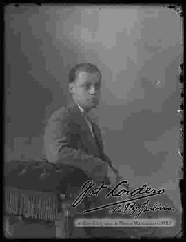 Foto de estudio de un joven sentado en un sillón