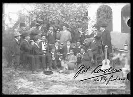 Grupo de varones (amigos), celebrando un acontecimiento con música y bebidas en el patio de una casa particular