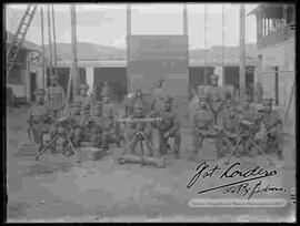 Comandante y cadetes del Colegio Militar, junto a una pieza de artillería y ametralladora pesada