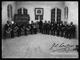 Conjunto de estudiantina dando concierto, en clase de música con su director.