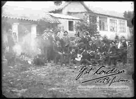 Grupo de amigos compartiendo bebidas y escuchando música en el patio de una casa particular por la celebración de un acontecimiento