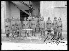 Cadetes junto a piezas de ametralladoras, en el patio del Colegio Militar