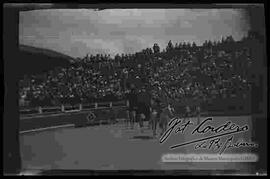 Torero domando a un toro, con el fondo de una gran multitud de aficionados, observando en la plaza Olimpic