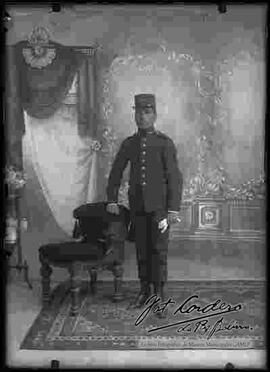 Foto de estudio de un soldado parado a lado de un sillón