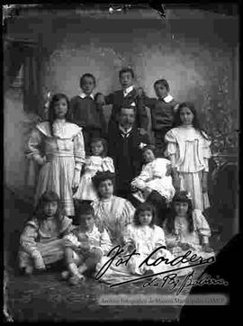 Foto de estudio de una familia: abuelo junto a sus nietos.