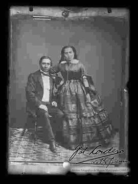 Reproducción fotográfica de una pareja que lleva puesto prendas de vestir del año de 1890.