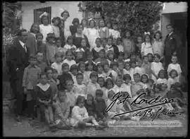 Grupo de niños y niñas junto a profesores, en el patio de una escuela