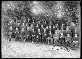 Grupo político posando en el huerto de una casa