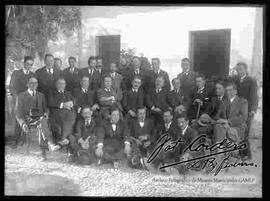 Grupo de varones, vestidos de traje y reunidos en el patio de una casa particular