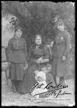 Una dama junto a sus hijas en el patio de una casa particular