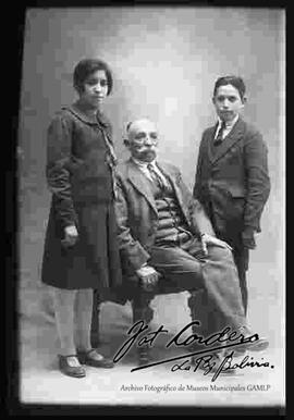 Foto de estudio de dos jóvenes parados junto a su abuelo