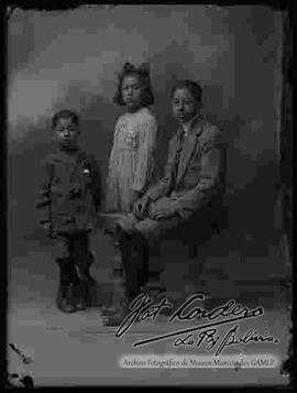 Foto de estudio de tres hermanitos. Dos niños y una niña