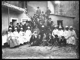 Familia y amigos en el patio de una casa celebrando carnavales.