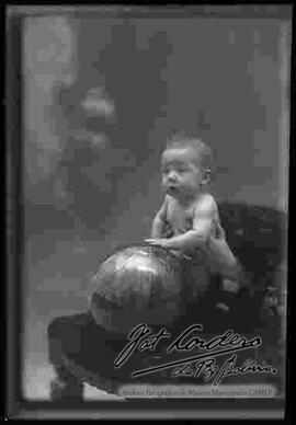 Foto de estudio de un bebe sujetando una pelota