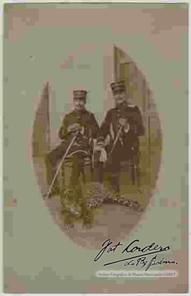 Dos Oficiales del Ejercito, sentados detrás de un leopardo que se encuentra echado en el piso, inscripción: "querido amigo reciba el mas afectuoso saludo de su amigo, Remigio Buitron desde Riberalta noviembre 20 de 1912. para el señor Julio Cordero, La Paz"