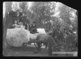 Desfile  por las fiestas  patrias del 6 de agosto, donde se puede ver una carrosa con niños adornada, con la imagen de un ángel y tirada por mulas.