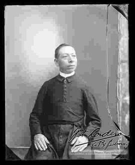 Foto de estudio de un sacerdote  de Don Bosco, que se encuentra sentado
