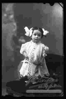 Foto de estudio de una niña pequeña, parada encima de un sillón