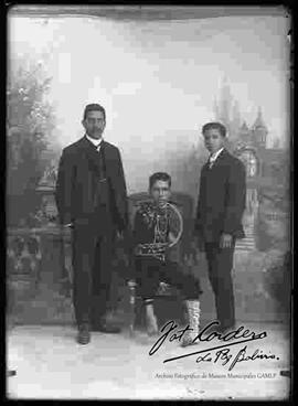 Foto de estudio del niño fenómeno junto a su padre y hermano.
