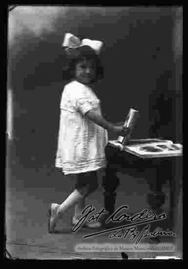 Foto de estudio de una niña que sostiene un libro