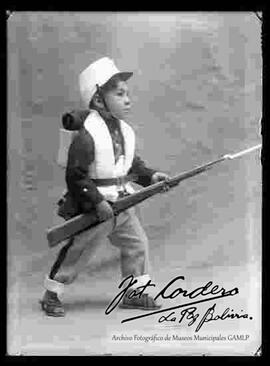 Foto de estudio de un niño vestido de un soldado colorado de Bolivia